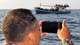 Nelayan Aceh Selamatkan Pengungsi Rohingya Anggota Marinir mengabadikan kapal yang ditumpangi pengungsi etnis Rohingya saat ditarik dari tengah laut menuju pesisir Bayu, Aceh Utara, Aceh, Rabu (24/6/2020). Sebanyak 94 orang pengungsi etnis Rohingya, terdiri dari 15 orang laki-laki, 49 orang perempuan dan 30 orang anak-anak ditemukan terdampar di tengah laut dengan kondisi kapal rusak, sebanyak 15 orang lainnya dilaporkan meninggal di laut selama mereka terdampar di perairan Indonesia hingga ke Aceh. ANTARA FOTO/Rahmad.