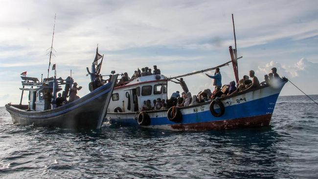 Nelayan Aceh Selamatkan Pengungsi Rohingya Kapal nelayan (kiri) mengikat kapal yang ditumpangi pengungsi etnis Rohingya untuk ditarik dari tengah laut menuju pesisir Bayu, Aceh Utara, Aceh, Rabu (24/6/2020). Sebanyak 94 orang pengungsi etnis Rohingya, terdiri dari 15 orang laki-laki, 49 orang perempuan dan 30 orang anak-anak ditemukan terdampar di tengah laut dengan kondisi kapal rusak, sementara sebanyak 15 orang lainnya dilaporkan meninggal di laut selama mereka terdampar di perairan Indonesia hingga ke Aceh. ANTARA FOTO/Rahmad/foc.