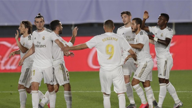 Real Madrid's Vinicius Junior, right, celebrates after scoring the opening goal with teammates during the Spanish La Liga soccer match between Real Madrid and Mallorca at Alfredo di Stefano stadium in Madrid, Spain, Wednesday, June 24, 2020. (AP Photo/Bernat Armangue)