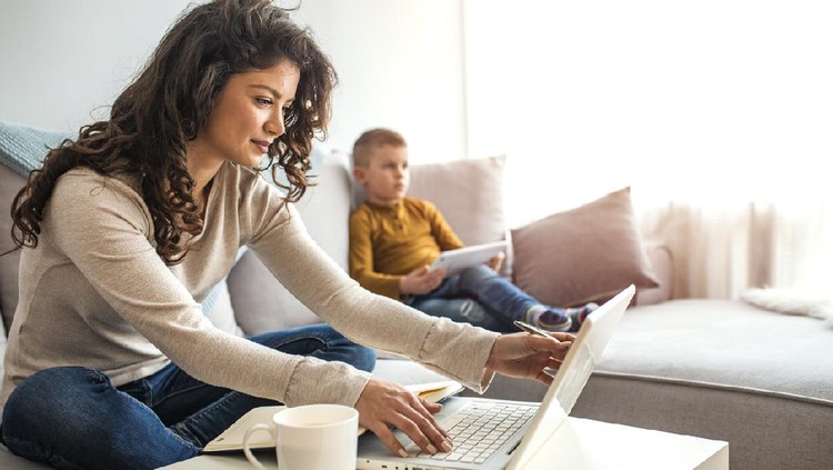 Multitasking mother working from home. Moms Can Balance Work and Family. Mother and son using technologies at table. Family is working on laptop and digital tablet at home.