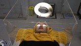 Nyalang Edisi 27 Juni 2020 A patient waits for treatment inside a protective acrylic box used as a precaution against the new coronavirus outbreak at the beauty clinic at Tambak Hospital in Jakarta, Indonesia, Tuesday, June 23, 2020. (AP Photo/Tatan Syuflana)