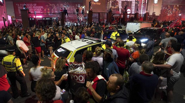 Liverpool supporters celebrate as they gather outside of Anfield Stadium in Liverpool, England, Friday, June 26, 2020 after Liverpool clinched the English Premier League title. Liverpool took the title after Manchester City failed to beat Chelsea on Wednesday evening. (AP photo/Jon Super)