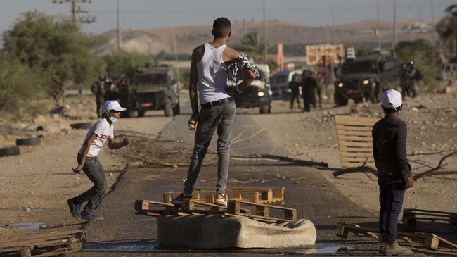 Palestinian demonstrators clashwith the Israeli troops during a protest against Israel's plan to annex parts of the West Bank and Trump's mideast initiative, at the village of Fasayil, in Jordan Valley, Wednesday, Jun. 24, 2020. (AP Photo/Majdi Mohammed)