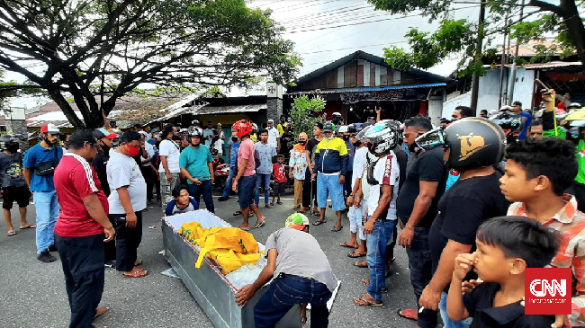 Warga Ambon membuang peti mayat setelah merampas jenazah dari ambulans dikawasan jalan Jenderal Sudirman, Desa Batu Merah, Kota Ambon, Maluku. Jumat, (26/6).