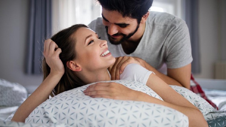 Cheerful young happy couple making massage at home