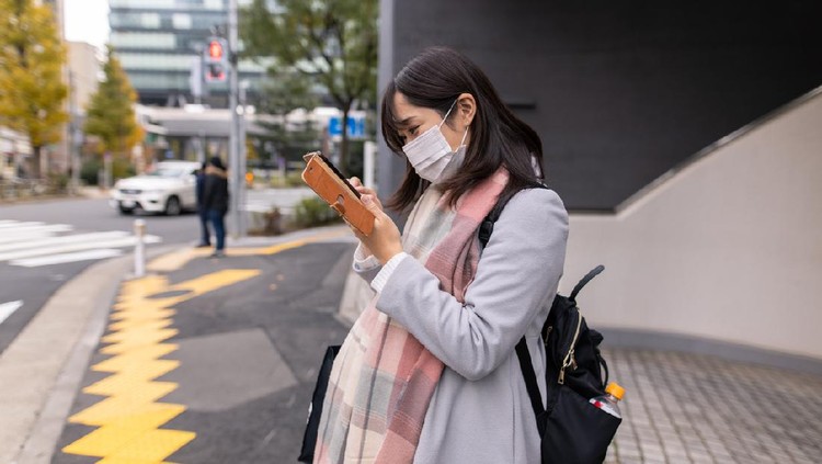 Kyiv, Ukraine - March 18, 2020: Pregnant woman and man with plaster on hand in protective medical mask walking down the street. Due to the coronavirus epidemic, the Ukrainian government has closed the subway.