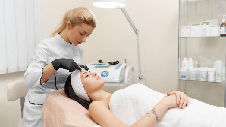 Ilustrasi klinik kecantikan Hardware cosmetology. Cosmetologist doing procedure of ultrasonic cleaning of face. Young woman getting ultrasonic peeling in beauty salon. Cosmetological clinic. Healthcare, clinic, cosmetology
