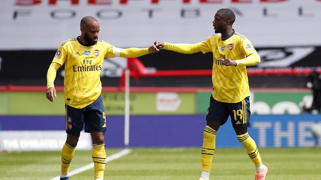 Arsenal's Nicolas Pepe, right, celebrates with his teammate, Alexandre Lacazette, left, after scoring the opening goal by penalty during the FA Cup sixth round soccer match between Sheffield United and Arsenal at Bramall Lane in Sheffield, England, Sunday, June 28, 2020. (Andrew Boyers/Pool via AP)