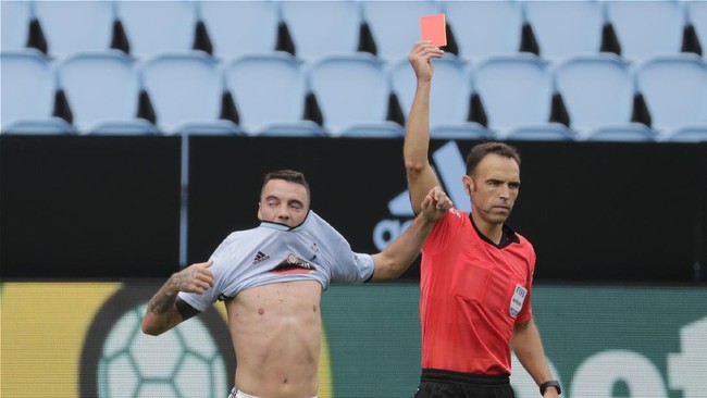 Referee Guillermo Cuadra, right, shows a red card to Celta Vigo's Iago Aspas after scored his side's second goal during a Spanish La Liga soccer match between RC Celta and Barcelona at the Balaidos stadium in Vigo, Spain, Saturday, June 27, 2020. (AP Photo/Lalo Villar)