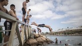 Aktivitas Warga Maroko Usai Lockdown Dilonggarkan Boys jump into a river to cool down after lockdown measures were lifted in Rabat, Morocco on Friday, June 26, 2020. Moroccans are re-experiencing a taste of the life before. In newly opened public spaces, every sip of coffee in a cafe, every dip in a river with friends, every moment of outdoor intimacy is savored, marking the end of more than three months of lockdown. With the exception of a few cities still struggling with high coronavirus infections, Morocco started entering new normality Thursday as the drum of social life began beating again. (AP Photo/Mosa'ab Elshamy)