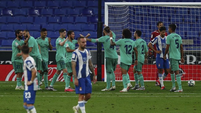 Real Madrid players, background, celebrate after scoring the opening goal during the Spanish La Liga soccer match between RCD Espanyol and Real Madrid at the Cornella-El Prat stadium in Barcelona, Spain, Sunday, June 28, 2020. (AP Photo/Joan Monfort)