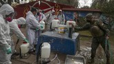 Lonjakan Kasus Kematian Akibat Corona di Chile Soldiers in full protection gear prepare to disinfect an area during an event where an army kitchen was serving food for people facing hardship because of lost income due to the new coronavirus pandemic, in Maipu, on the outskirts of Santiago, Chile, Tuesday, June 16, 2020. (AP Photo/Esteban Felix)