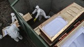 Lonjakan Kasus Kematian Akibat Corona di Chile Workers collect and stack the coffins of people that have been recently cremated amid the new coronavirus pandemic, at the La Recoleta cemetery in Santiago, Chile, Sunday, June 28, 2020. The coffins are collected, destroyed, and processed by a company specialized in organic waste. (AP Photo/Esteban Felix)