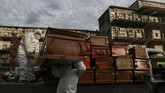 Lonjakan Kasus Kematian Akibat Corona di Chile Workers collect and stack the coffins of people that have been recently cremated amid the new coronavirus pandemic, at the La Recoleta cemetery in Santiago, Chile, Sunday, June 28, 2020. The coffins are collected, destroyed, and processed by a company specialized in organic waste. (AP Photo/Esteban Felix)