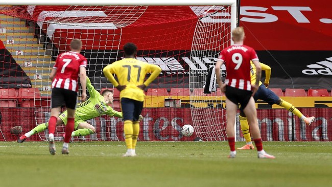 Arsenal's Nicolas Pepe, right, scores the opening goal by penalty during the FA Cup sixth round soccer match between Sheffield United and Arsenal at Bramall Lane in Sheffield, England, Sunday, June 28, 2020. (Andrew Boyers/Pool via AP)