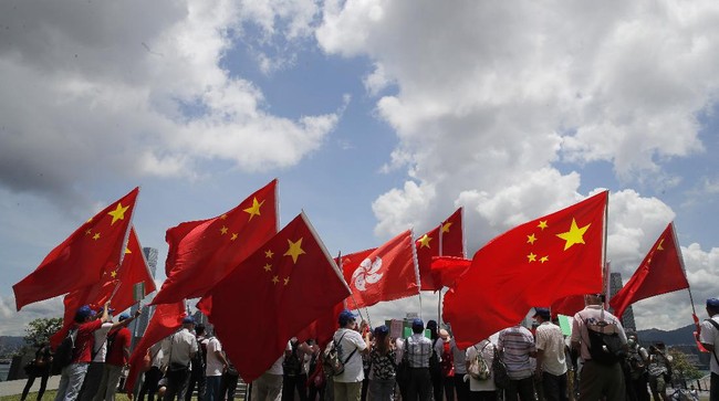 Pro-China supporters hold Chinese and Hong Kong national flags during a rally to celebrate the approval of a national security law for Hong Kong, in Hong Kong, Tuesday, June 30, 2020. Hong Kong media are reporting that China has approved a contentious law that would allow authorities to crack down on subversive and secessionist activity in Hong Kong, sparking fears that it would be used to curb opposition voices in the semi-autonomous territory. (AP Photo/Kin Cheung)
