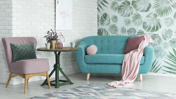 rumah minimalis Green table with plant between pink chair and blue sofa in floral living room with wallpaper and poster