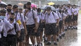 Anak-anak Thailand Kembali Masuk Sekolah Students wearing a face mask to help curb the spread of the coronavirus as they arrive at Samkhok School during rain in Pathum Thani, outside Bangkok, Wednesday, July 1, 2020. Thailand has begun a fifth phase of relaxations of COVID-19 restrictions, allowing the reopening of schools and high-risk entertainment venues such as pubs and massage parlors that had been shut since mid-March. (AP Photo/Sakchai Lalit)