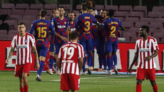 FC Barcelona, background, celebrate their side's second goal during the Spanish La Liga soccer match between FC Barcelona and Atletico Madrid at the Camp Nou stadium in Barcelona, Spain, Tuesday, June 30, 2020. (AP Photo/Joan Monfort)