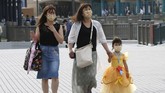 Disneyland Jepang dibuka People wearing face masks to protect against the spread of the new coronavirus walk toward the entrance to Tokyo Disneyland in Urayasu, near Tokyo, Wednesday, July 1, 2020. Tokyo Disneyland reopens for the first time in four months after suspending operations due to coronavirus concerns. (AP Photo/Koji Sasahara)