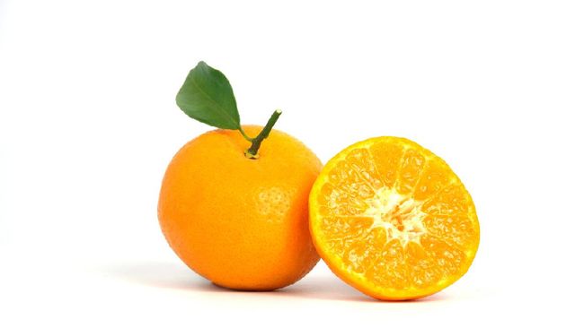 Half sliced and raw of Citrus sinensis ( called jeruk baby santang ) with leaves, local fresh fruit from Indonesia. Isolated fruit on a wooden basket / bowl. Image photo