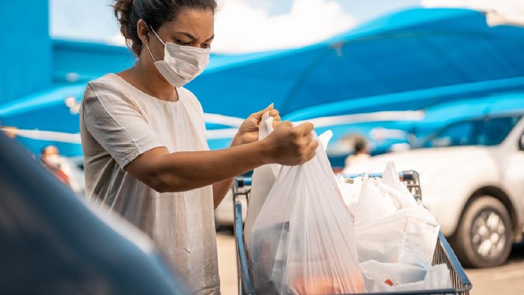 Kantong plastik Woman finishing shopping at the supermarket during the COVID-19 pandemic in 2020