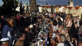 Makan Malam di Meja Sepanjang 500 meter di Jembatan Charles Praha Residents sit to dine on a 500 meter long table set on the medieval Charles Bridge, after restrictions were eased following the coronavirus pandemic in Prague, Czech Republic, Tuesday, June 30, 2020. (AP Photo/Petr David Josek)