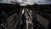 Makan Malam di Meja Sepanjang 500 meter di Jembatan Charles Praha Residents sit to dine on a 500 meter long table set on the medieval Charles Bridge, after restrictions were eased following the coronavirus pandemic in Prague, Czech Republic, Tuesday, June 30, 2020. (AP Photo/Petr David Josek)