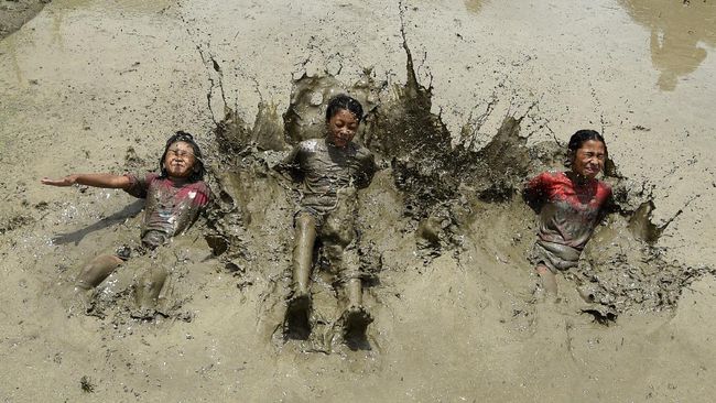 In this photograph taken on June 29, 2020 children play in a rice paddy field during 