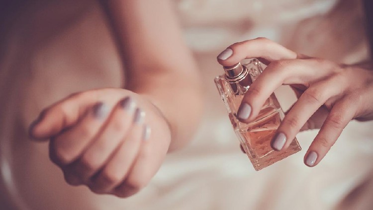 bride applying perfume on her wrist