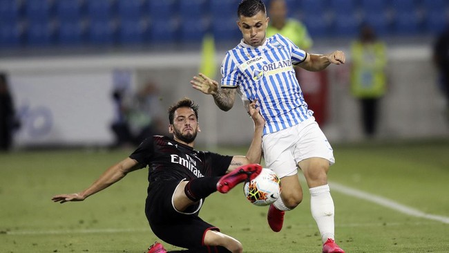 AC Milan's Hakan Calhanoglu, left, battles for the ball with Spal's Gabriel Strefezza during an Italian Serie A soccer match between Spal and Milan at the Paolo Mazza stadium in Ferrara, Italy, Wednesday, July 1, 2020. (Filippo Rubin/LaPresse via AP)