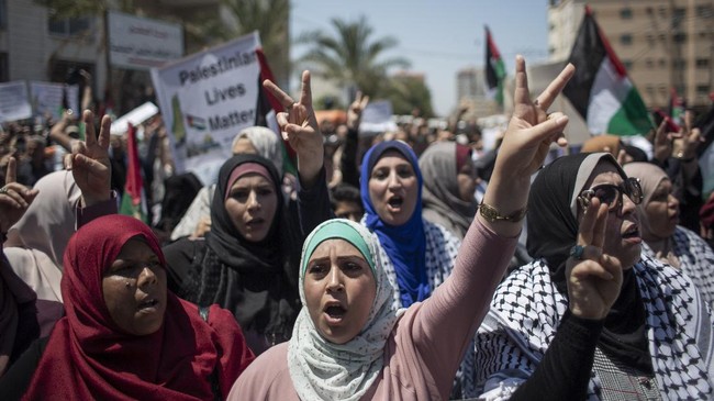 Palestinian women chant slogans and flash victory signs as they demonstrate against Israeli plans for the annexation of parts of the West Bank, in Gaza City, Wednesday, July 1, 2020. (AP Photo/Khalil Hamra)