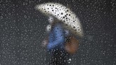 Nyalang Edisi 4 Juli 2020 Raindrops are seen on a taxi window while a woman passes by a closed store in Buenos Aires on June 30, 2020, a day before authorities tighten virus lockdown measures against the spread of the novel coronavirus, COVID-19. - The country went into lockdown on March 20 to help prevent the spread of the novel coronavirus, but those measures have been gradually eased in recent weeks. However, following a spike in coronavirus cases in the capital, a new lockdown has been imposed on the greater Buenos Aires area -- home to more than a third of the country's 44 million people -- from July 1-17. (Photo by Juan MABROMATA / AFP)