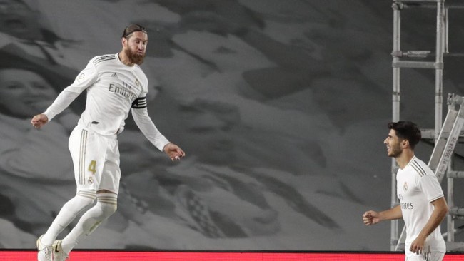 Real Madrid's Sergio Ramos, left, celebrates after scoring his side's opening goal from a penalty shot during the Spanish La Liga soccer match between Real Madrid and Getafe at the Alfredo di Stefano stadium in Madrid, Spain, Thursday, July 2, 2020. (AP Photo/Bernat Armangue)