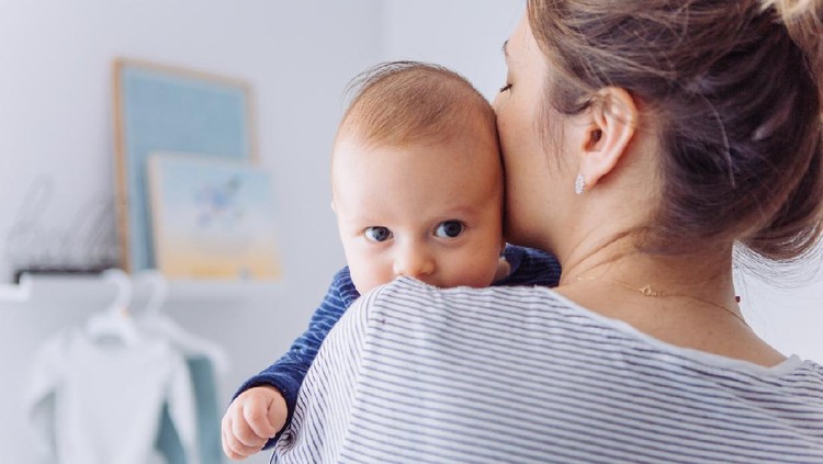 1144110189 Mother carrying baby son in bedroom, they share moment of love