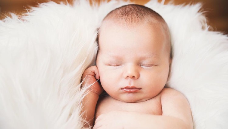 Sleeping newborn baby on white blanket. Beautiful portrait of little child girl 7 days, one week old.