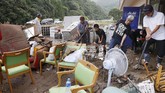 Banjir Bandang Jepang Tewaskan 20 Orang Workers try to clean their nursing home following a heavy rain in Ashikita town, Kumamoto prefecture, southern Japan Saturday, July 4, 2020. Heavy rain in southern Japan triggered flooding and mudslides on Saturday, leaving more than a dozen people presumed dead, some missing and dozens stranded on rooftops waiting to be rescued, officials said. (Takuto Kaneko/Kyodo News via AP)