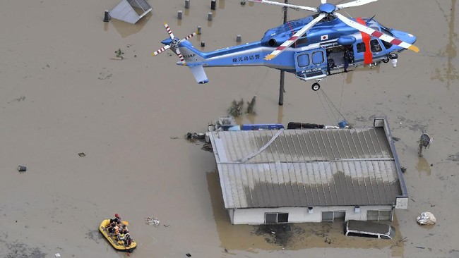 Rescue operation is conducted in a flooded area following a heavy rain in Hitoyoshi, Kumamoto prefecture, southern Japan Saturday, July 4, 2020. Heavy rain in southern Japan triggered flooding and mudslides on Saturday, leaving more than a dozen people presumed dead, some missing and dozens stranded on rooftops waiting to be rescued, officials said. (Kyodo News via AP)