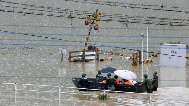 Japan Ground Self-Defense Force members evacuate people to a safer place by boat in Kuma village, Kumamoto prefecture, southwestern Japan, Sunday, July 5, 2020. Heavy rain in the Kumamoto region triggered flooding and mudslides Saturday and left dozens still being stranded at their homes and other facilities. (Kota Endo/Kyodo News via AP)