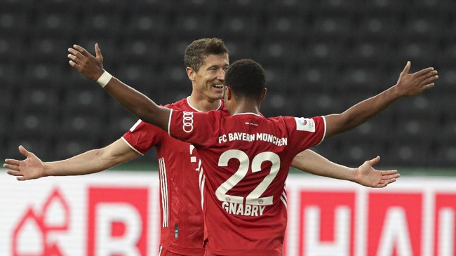 Bayern's Robert Lewandowski, left, celebrates after scoring his side's third goal with teammate Serge Gnabry during the German soccer cup (DFB Pokal) final match between Bayer 04 Leverkusen and FC Bayern Munich in Berlin, Germany, Saturday, July 4, 2020. (AP Photo/Michael Sohn)