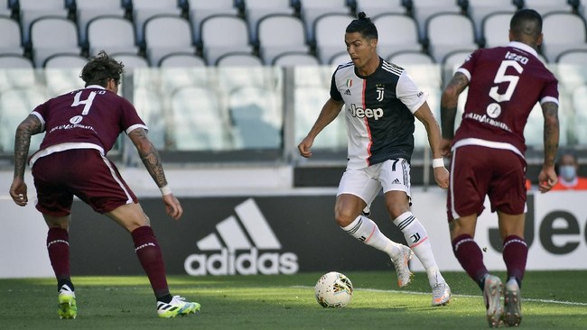 Juventus' Cristiano Ronaldo, center, goes for the ball ahead of Torino's Lyanco, left, and Armando Izzo, during the Serie A soccer match between Juventus and Torino, at the Allianz Stadium in Turin, Italy, Saturday, July 4, 2020. (Marco Alpozzi/LaPresse via AP)