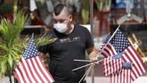 Libur Akhir Pekan di Amerika Marvin Turcios puts out American flags at Ocean's 10 restaurant on Miami Beach, Florida's famed Ocean Drive on South Beach, July 4, 2020. The Fourth of July holiday weekend began Saturday with some sobering numbers in the Sunshine State: Florida logged a record number of people testing positive for the coronavirus. (AP Photo/Wilfredo Lee)