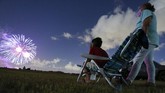 Libur Akhir Pekan di Amerika Javonnie Jackson, 9, left, sits with his grandmother Zoraida Rullan, 69, watching fireworks explode over Nathan Benderson Park on Friday, July 3, 2020, in Sarasota, Fl. The pair were reunited after nearly five months of separation due to the coronavirus. (Jonah Hinebaugh/Tampa Bay Times via AP)