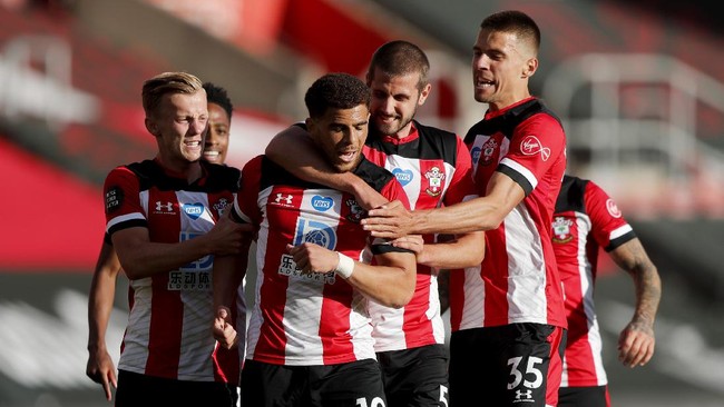 Southampton's Che Adams, second left, is congratulated by teammates after scoring his team's first goal during the English Premier League soccer match between Southampton and Manchester City at St. Mary's Stadium in Southampton, England, Sunday, July 5, 2020. (AP Photo/Frank Augstein,Pool)
