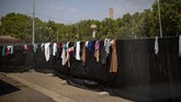 Buruh Migran Spanyol Kala Pandemi Clothes belonging to migrants hang on a fence surrounding an exhibition center turned into temporary seasonal workers' shelter in Lleida, Spain, Thursday, July 2, 2020. Authorities in northeast Spain have ordered the lockdown of a county around the city of Lleida due to worrying outbreaks of the COVID-19 virus. Catalan regional authorities announced Saturday, July 4, 2020 that as of noon local time movement will be restricted to and from the county of El Segriá around Lleida which is home to over 200,000 people. Residents will have until 4 p.m. to enter the area. The new outbreaks are linked to agricultural workers in the rural area. (AP Photo/Emilio Morenatti)
