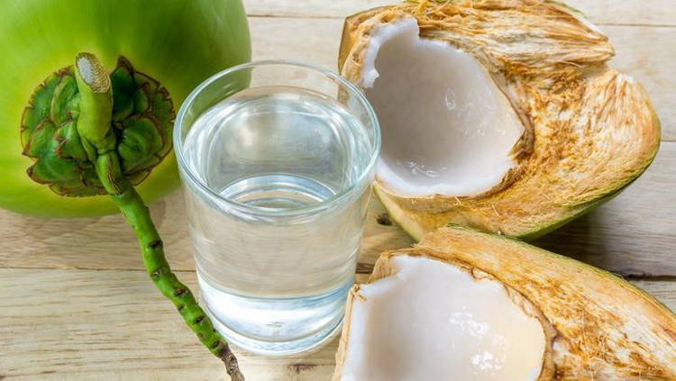 Khasiat air kelapa Tropical green coconuts opened for the drinking water with straws.