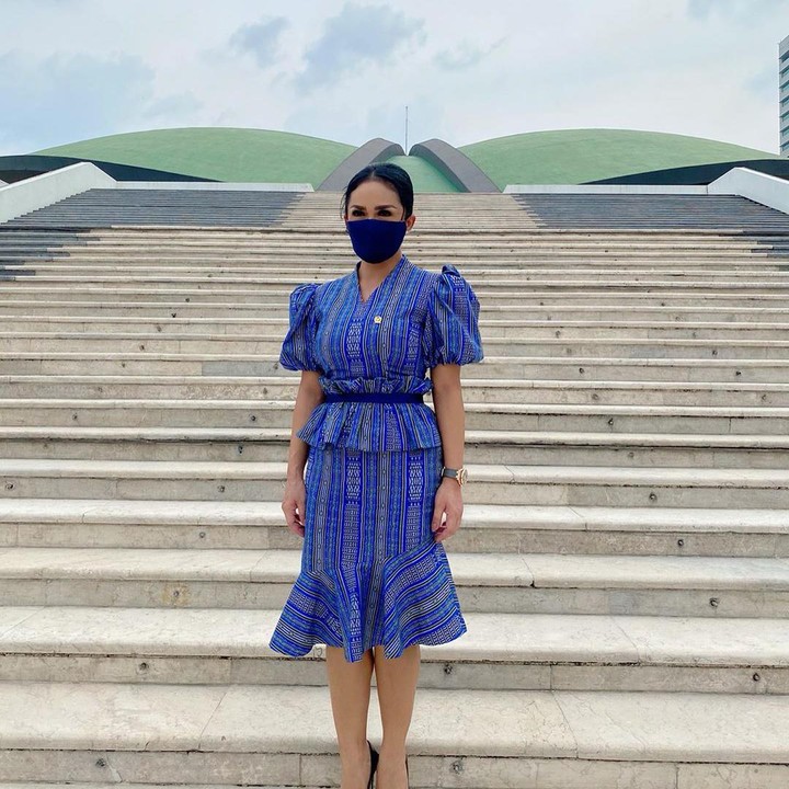 <p>Dalam balutan dres tenun dengan nada warna biru tua, KD berpose di depan gedung DPR nampak cantik dan anggun. (Foto: Instagram @krisdayantilemos)</p>