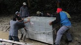 Mengembalikan Ida Petugas menurunkan kerangkeng berisi Harimau Sumatra liar dari perahu sebelum proses pelepasliaran di kawasan Taman Nasional Gunung Leuser (TNGL) yang berdampingan dengan Kawasan Ekosistem Leuser, Provinsi Aceh.