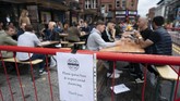 Pub di Inggris Kembali Dibuka Members of the public are seen at a bar in Manchester's Northern Quarter, England, Saturday July 4, 2020. England is embarking on perhaps its biggest lockdown easing yet as pubs and restaurants have the right to reopen for the first time in more than three months. In addition to the reopening of much of the hospitality sector, couples can tie the knot once again, while many of those who have had enough of their lockdown hair can finally get a trim. (AP Photo/Jon Super)