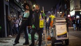 Pub di Inggris Kembali Dibuka A woman poses with a street cleaner in Soho as late-night drinkers continue into the early hours of Sunday morning as coronavirus lockdown restrictions are eased across England, Sunday July 5, 2020. (Victoria Jones/PA via AP)